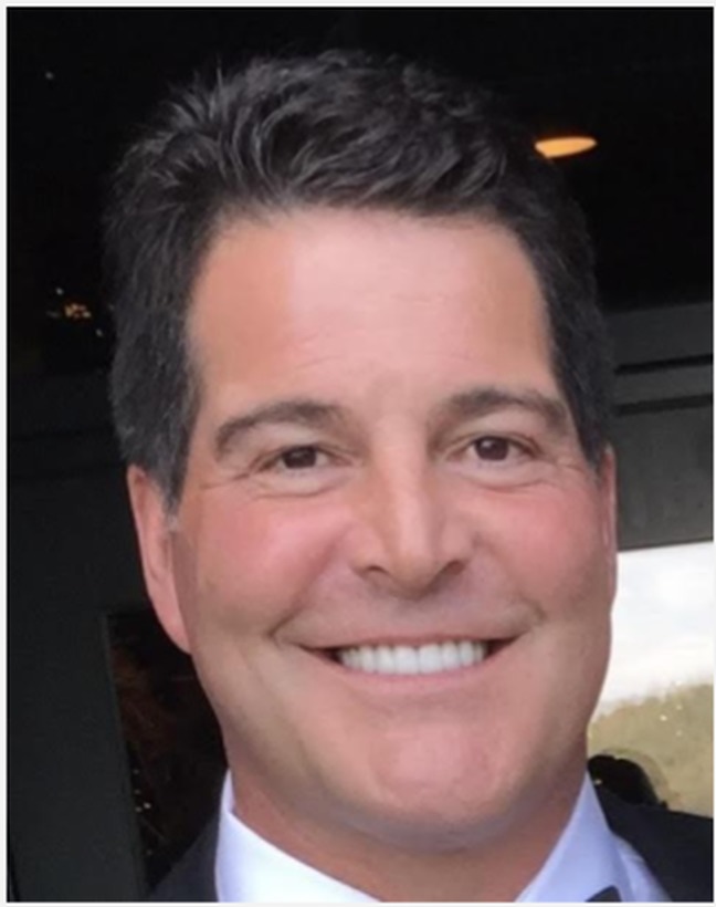 Andy Bivona, board member of Ryan Trading Co., smiling in a dark suit